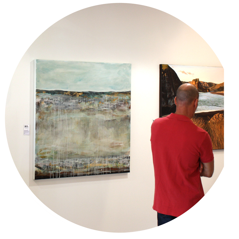 Interior View of Black Door Gallery. Purchase a work of original New Zealand art. Select from over 100 New Zealand artists. Client enjoying an artwork in exhibition.